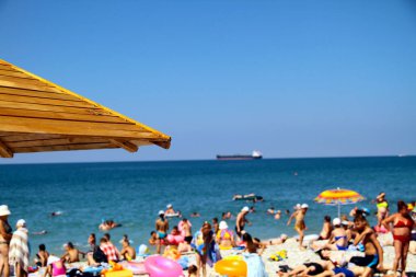 Plaj ahşap şemsiyeler ile deniz manzaralı tanker.