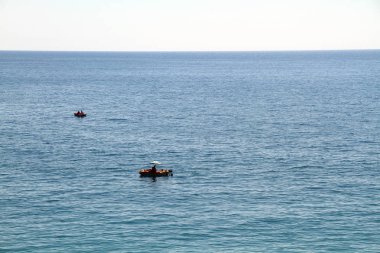 Turistler denizde bir katamaran yelken