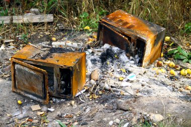 Yangından sonra yanmış mikrodalga. Konsept: ürün sigortası, risk yönetimi.