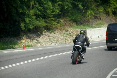 Bir motosiklet virajda yolda biner. sürüş sırasında eğlenmek. Tek tek metniniz için kopyalama alanı.