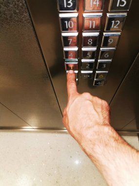 Gösterge panelindeki asansördeki adamın eli birinci kattaki düğmeye basar..