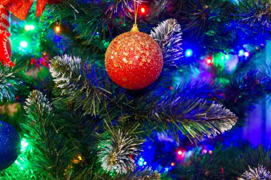 Dizüstü bilgisayarının yanında oyuncakları olan bir Noel ağacı. Hediye alışverişi, Noel ışıkları ve diğer mevsimsel tatil sembolleri olan dizüstü bilgisayar..