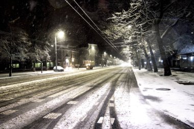 Geceleri karlı bir yolda kar makinesi