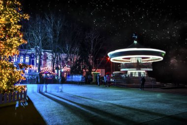 yıldızlı gökyüzü arka planı Noel ağacı yakınındaki geceleri parlayan atlıkarınca çocuk