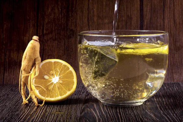 Ginseng natürmort, kahverengi ahşap arka plan üzerinde çay içmeye