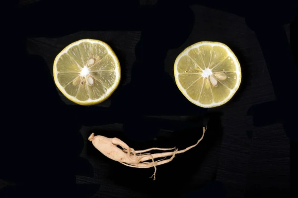 smiling attractive face from lemons and genseng on a dark  background, concept of happiness and joy