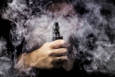 adam arka plan siyah yakın çekim duman tarafından çevrili vape el ile