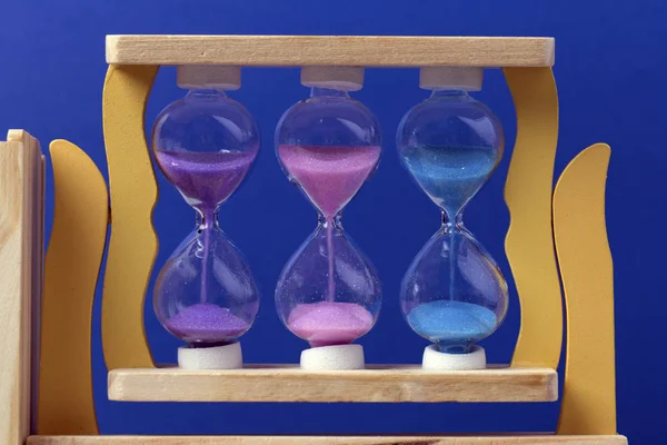 Цветные Песочные Часы Фоне Синей Стены — стоковое фото