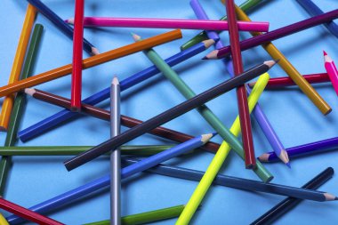 mavi bir arka plan üzerinde kaotik bir şekilde yerleştirilen çizim için renkli kalemler