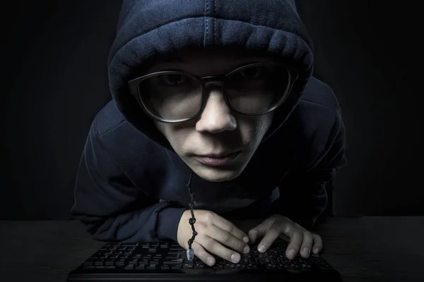 Haker Kaptur Okulary Siedzi Klawiaturze Dziwnie Patrząc Kamery Czarnym Tle — Zdjęcie stockowe