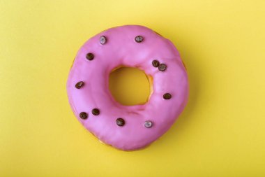 Sarı arka planda pembe kremalı çörekler.