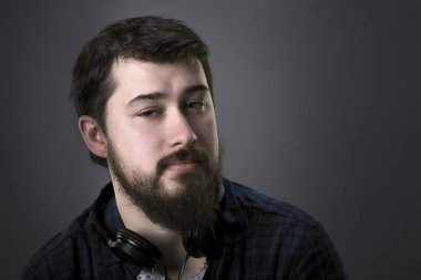 gri bir arka plan üzerinde sakallı bir adam portresi