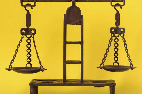 bronze antique scales on a yellow background, symbol of justice