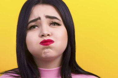 yakın çekim yanakları kabarık ve ona kaşları sarı bir arka plan üzerinde kaldırdın bir artı-size kız portresi