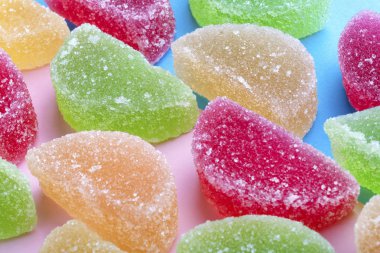 şeker kristalleri pembe-mavi arka plan üzerinde renkli jöle dilimlerle