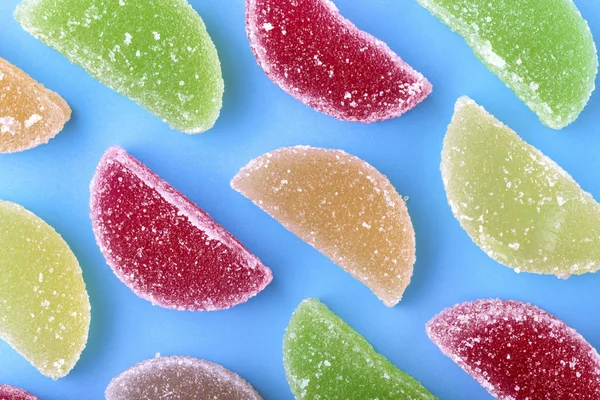 renkli meyve dilimleri ile mavi bir arka plan üzerinde şeker kristalleri jöle