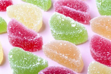 renkli meyve jöle ile şeker kristalleri, pembe bir arka plan üzerinde