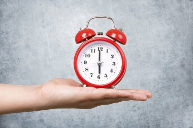 Kırmızı saat bir beton duvar arka taraftan alarm ile kavram sabah uyanmak.