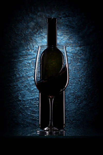 Bicchiere di vino rosso e una bottiglia — Foto Stock