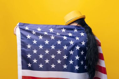 Sarı arka planda Amerikan bayrağı taşıyan kız, Amerikan bayrağı taşıyan şık şapkalı kız.