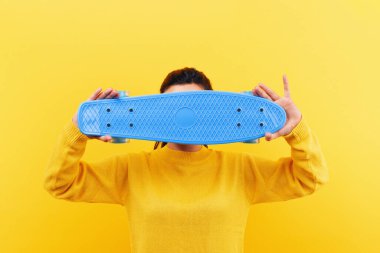 Sarı arka planda kaykay yapan kız, resim modeli.