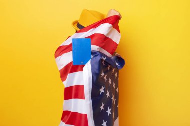 Sarı arka planda Amerikan bayrağı olan kişi, göçmenlik kavramı