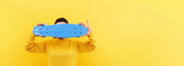 girl with skateboard over yellow background, panoramic mock-up image
