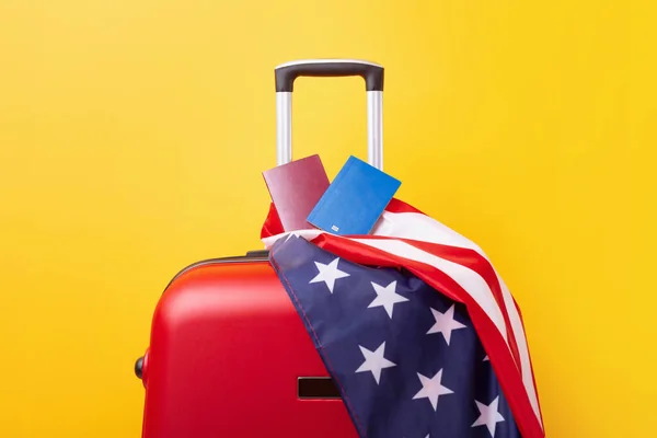 Passports with USA flag on red suitcase. American visa, work and travel concept