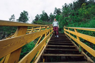 Dağlarda merdivenlerden kız gider.