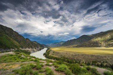 Nehir yüksek dağların arasında. Dağ ve thunderclouds, yağmurlu bulutlar.