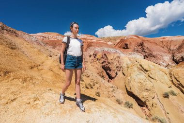 Turist kızın bir dağın tepesinde bir sırt çantası ile. Kırmızı altay dağlarında. Gezgin dağlarda