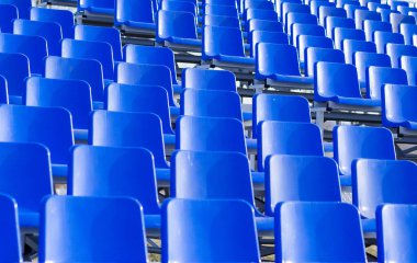 Tribünlerdeki mavi plastik koltukların arka planı. Stadyumdaki boş koltuklar. Taraftarlar ve izleyiciler için yerler.