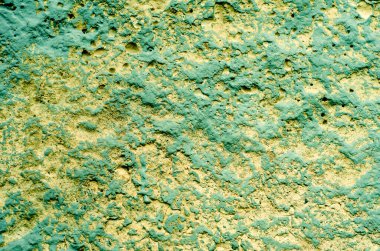 Sarı-yeşil arka plan. Betonun pürüzlü yüzeyi.