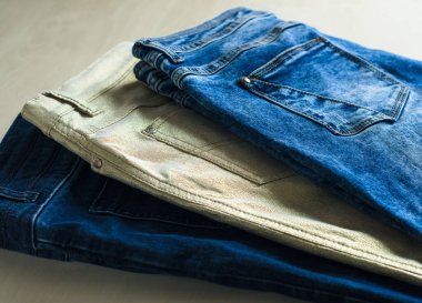 Masanın üzerinde çok renkli kotlar var. Denim. Günlük kıyafet..
