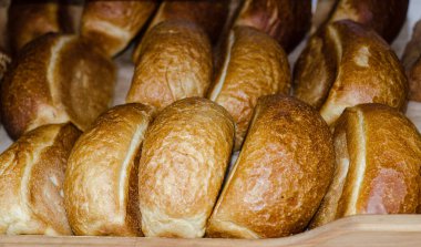 Mağaza rafında taze ekmek somunları. Üçgen şekilli fırın ürünleri. Fırın. İlk gereksinimin ürünleri. Yemek..