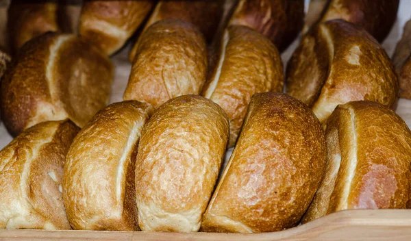 Mağaza rafında taze ekmek somunları. Üçgen şekilli fırın ürünleri. Fırın. İlk gereksinimin ürünleri. Yemek..