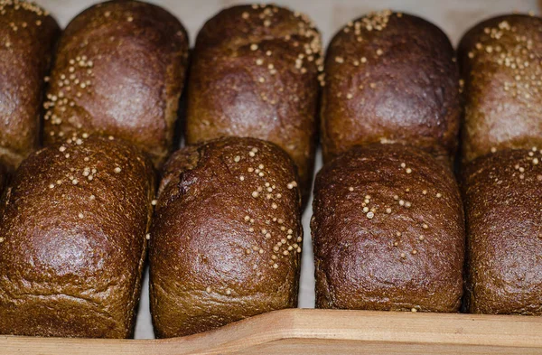 Loaves of fresh black bread on the store shelf. Bakery. The products of the first necessity. Meal.