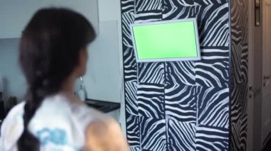 Kadın rahat evde izlerken Tv. kanepede uzanmış yeşil ekran televizyon izlerken kız