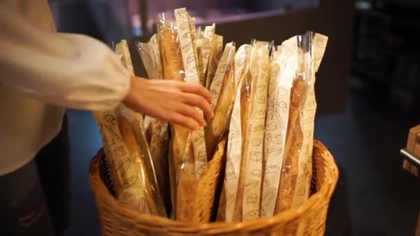 Meisje kiest voor vers brood in de winkel — Stockvideo