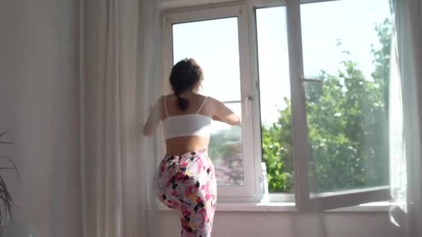 Aantrekkelijk meisje wast windows thuis. Om het huis schoon te maken. — Stockvideo