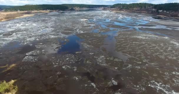 Antenne: Vlucht boven winter rivier tijdens ijs drift. De ice floes zijn langzaam drijvend op de rivier — Stockvideo