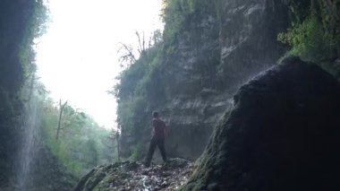 Tropikal yağmur ormanlarında uzanmış ayakta silah genç adam