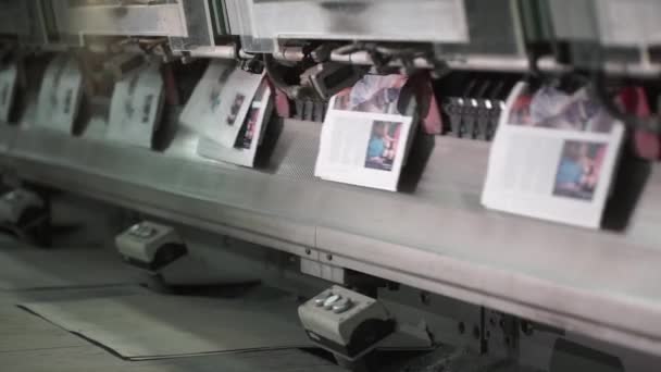 Eine große Menge vorgefertigter Zeitungen auf einem Förderband der Druckerei. — Stockvideo