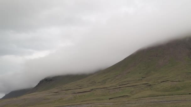 Awesome bakgrund av isländska bergen med stormigt moln och gräsbevuxen ängar. Landskapet på Island. — Stockvideo