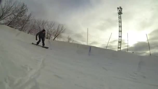 Extreme snowboarder riding fresh powder snow down the steep mountain slope — Stock Video
