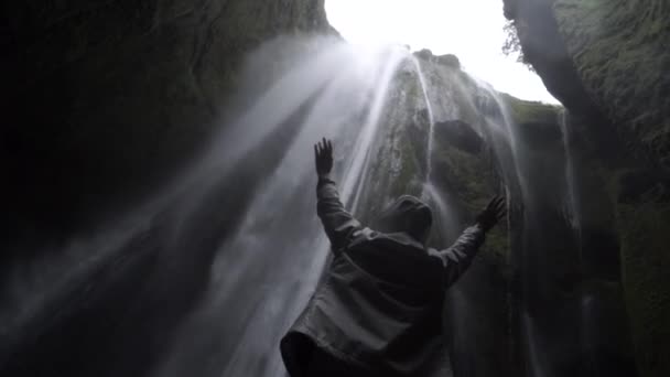 Jeune voyageuse debout près des cascades en Islande. Fille levant les mains et se sentant heureux . — Video