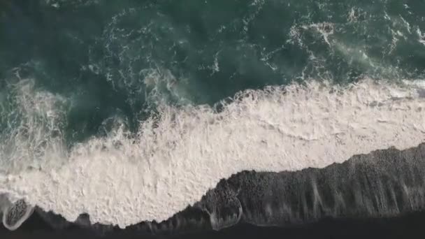 回到岸上的黑色火山的海滩上冰岛的泡沫对野生波的鸟瞰图. — 图库视频影像