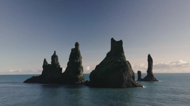 Copter voa para longe da praia vulcânica preta e troll toes penhascos no mar na Islândia. Bela paisagem — Vídeo de Stock