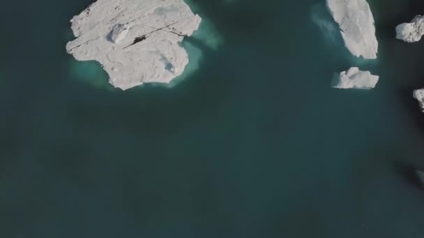 Vol aérien avec drone au-dessus des icebergs flottant dans la lagune de Jokulsarlon par la côte sud de l'Islande — Video