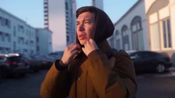 A kaukázusi jó látszó ember téli ruhák felmelegedés a vállát, kézzel állva kívül közelről a hideg téli napon. Külső. — Stock videók